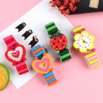 3-delat armbandsur i trä för barn med rosa bakgrund och vitt blad