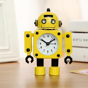 Väckarklocka i form av en gul robot på brun möbel med böcker