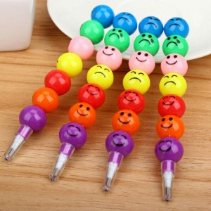 20 färgglada 3D-smiley-pennor på ett träbord