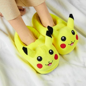 Barntofflor i form av en Pikachu i plysch som glider över fötterna med en vit filt