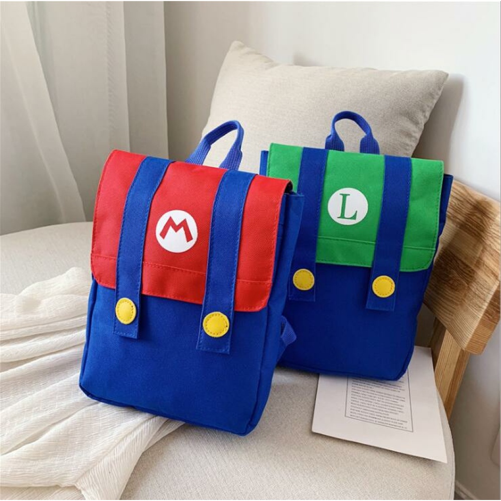 Super Mario-ryggsäck för barn röd och blå, grön och blå på en säng med kudde