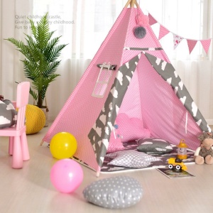 Liten vit och rosa tipi för ett barns sovrum med en grön växt och ballonger på golvet, med en rosa stol
