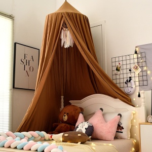 Barnens sängtält på en säng i ett sovrum med bilder i fönstret