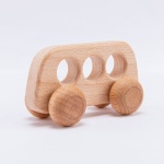 Leksaksfordon i trä med hål inuti och hjul i trä