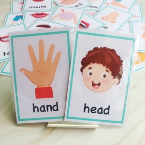 Babykortspel med hand och huvud och andra kort på en säng