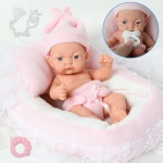 Nyfödd docka i rosa och vit kudde