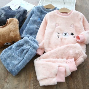 Pyjamasset med varm katt i rosa och blått för barn på ett träbord