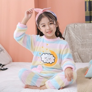 Pyjamas i fleece med färgglatt månmotiv för barn med ett molnmotiv på framsidan i ett vardagsrum på en vit matta