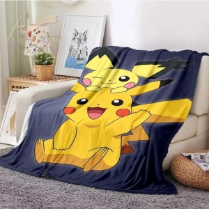 Pokémon Pichu och Pikachu-filt för barn i svart och gult på en beige soffa