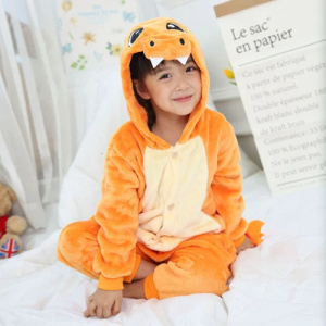 Söt tecknad pyjamas för barn i orange med liten flicka på en säng i vitt