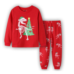 Dinosauriejulpyjamas med julgran för barn mot en vit bakgrund