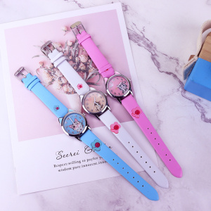 tre flickklockor som ligger platt på ett marmorbord, en blå, en vit och en rosa, med en söt liten katt ritad på urtavlan