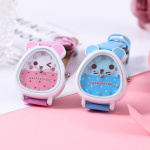 klocka för flicka, två färger av samma modell presenteras tillsammans, en rosa och en blå, de är på ett rosa stöd, urtavlan föreställer huvudet på en teddybjörn