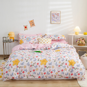 Sovrum med en säng i mitten, ett rosa mönstrat täcke och dekorativa element
