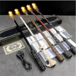 Baguette magique Harry Potter cracheuse de feu, exposée sur sa boite de rangement, avec une petite flamme au bout pour illustrer son fonctionnement.