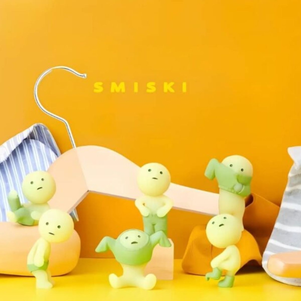 IMG_Smiski_Dressing_figurer_7 flera Smiski-figurer kan ses mot en orange bakgrund