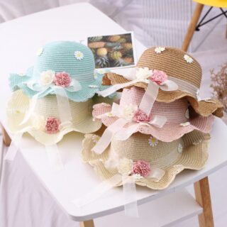 Chapeau d'été pour les bébés disposés sur une table, on peut voir toutes les couleurs disponibles.