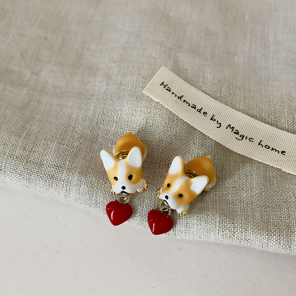 Boucle d'oreille à motif chien pour fille disposée sur un tissu de couleur grise.